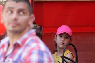 Little girl behind a bodyguard looking up to a speaker on the podium.